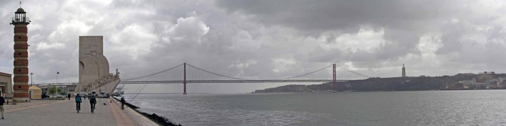 Leuchturm und Entdeckerdenkmal in Belém mit der Brücke des 25. April über den Tejo im Hintergrund